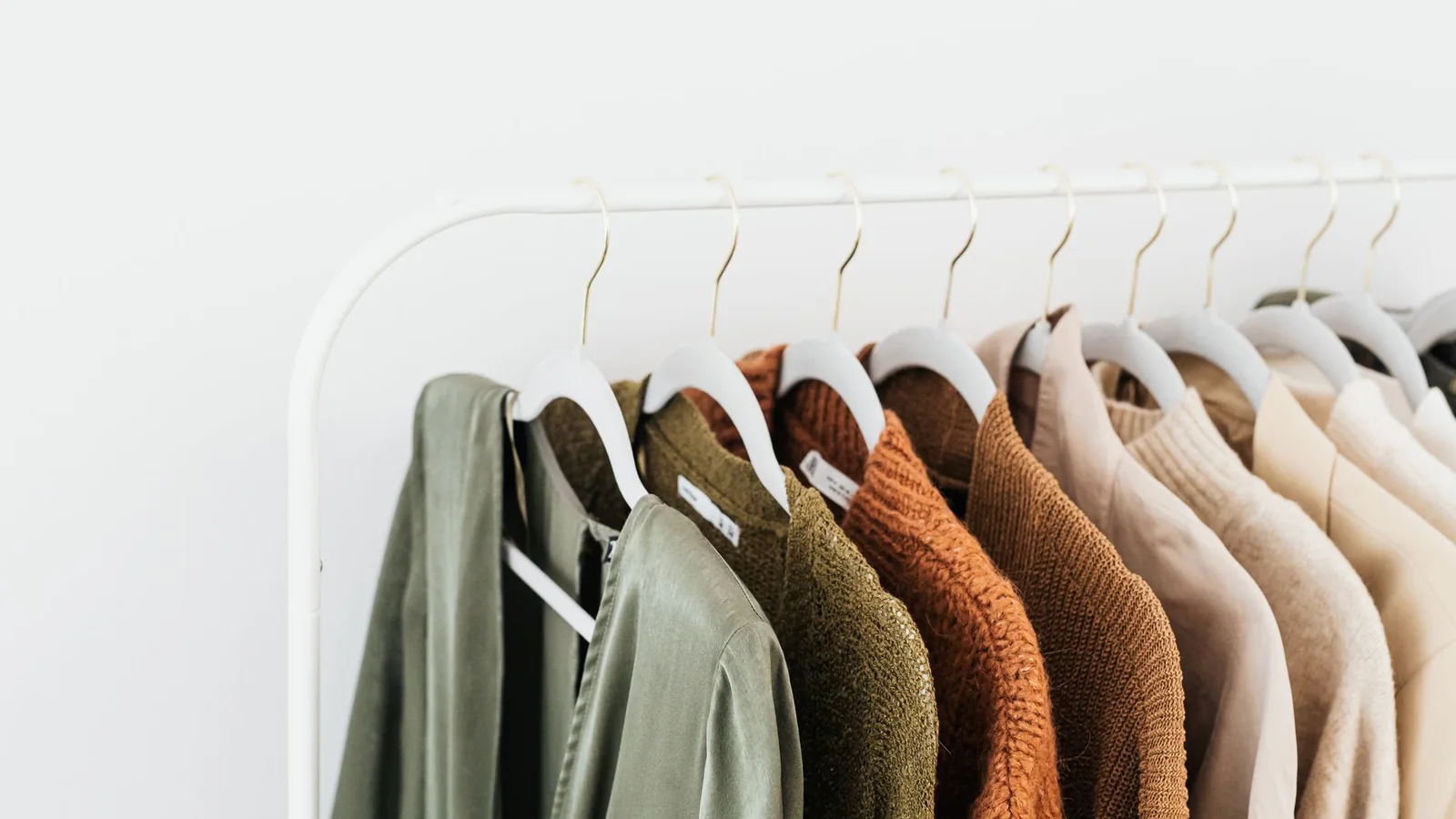 Prendas de distintos colores organizadas en un perchero de casa