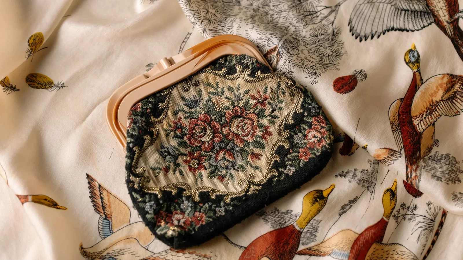 Un bolso pequeño de noche abierto con objetos esenciales y una tarjeta