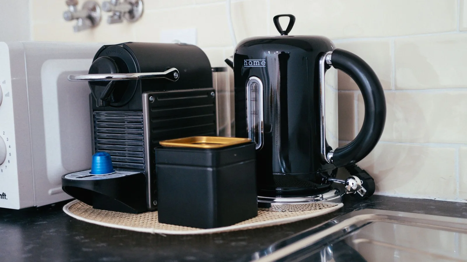 Una cafetera sencilla junto a una taza en una cocina luminosa