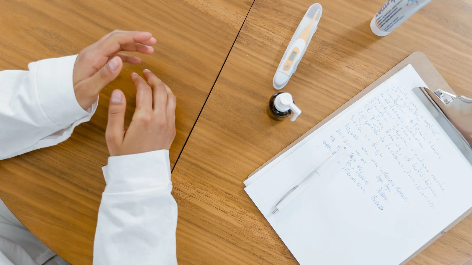 Una crema de manos junto a objetos cotidianos sobre un escritorio