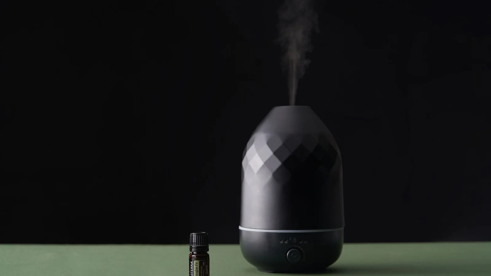Un difusor de aroma sobre una mesa de casa junto a una ventana