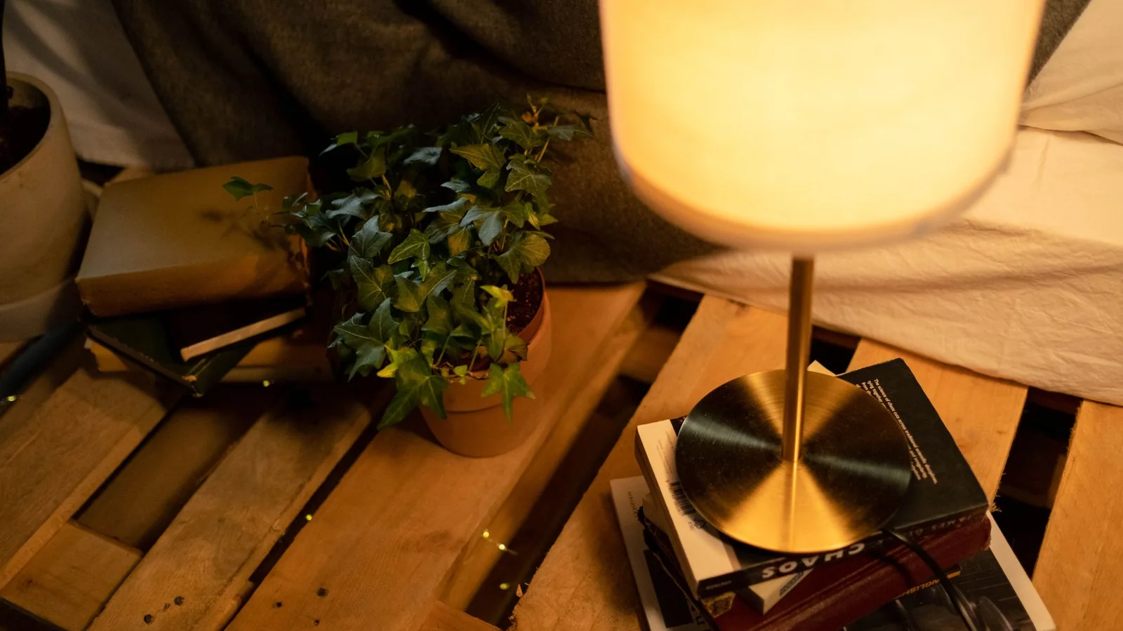 Una lámpara de lectura junto a un libro y una mesa auxiliar en casa