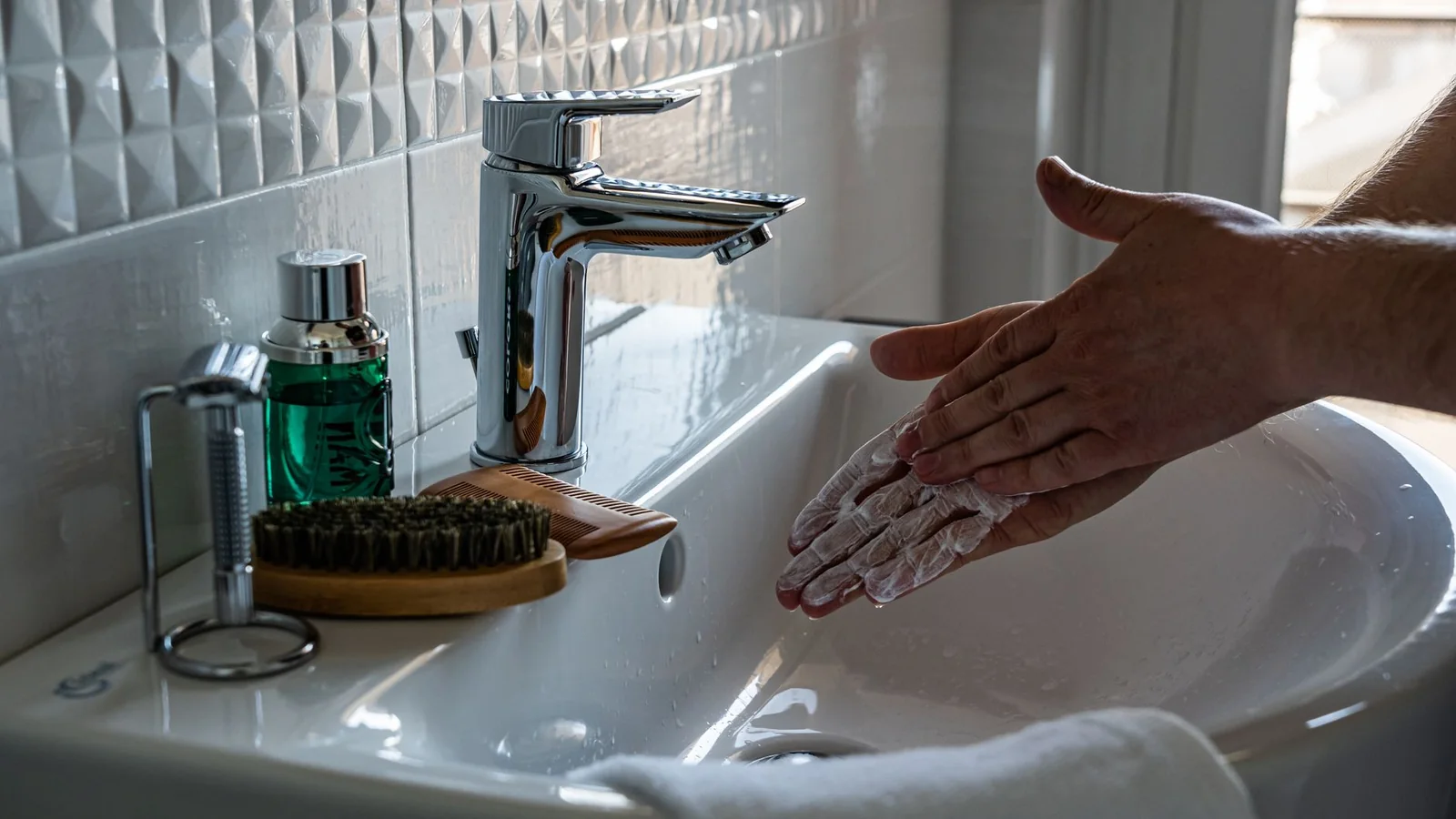 Brochas de maquillaje lavándose con suavidad en un lavabo claro