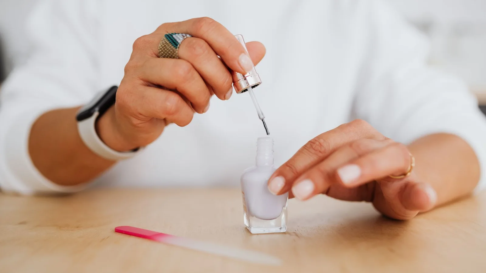 Esmaltes y herramientas de manicura dispuestos sobre una mesa luminosa