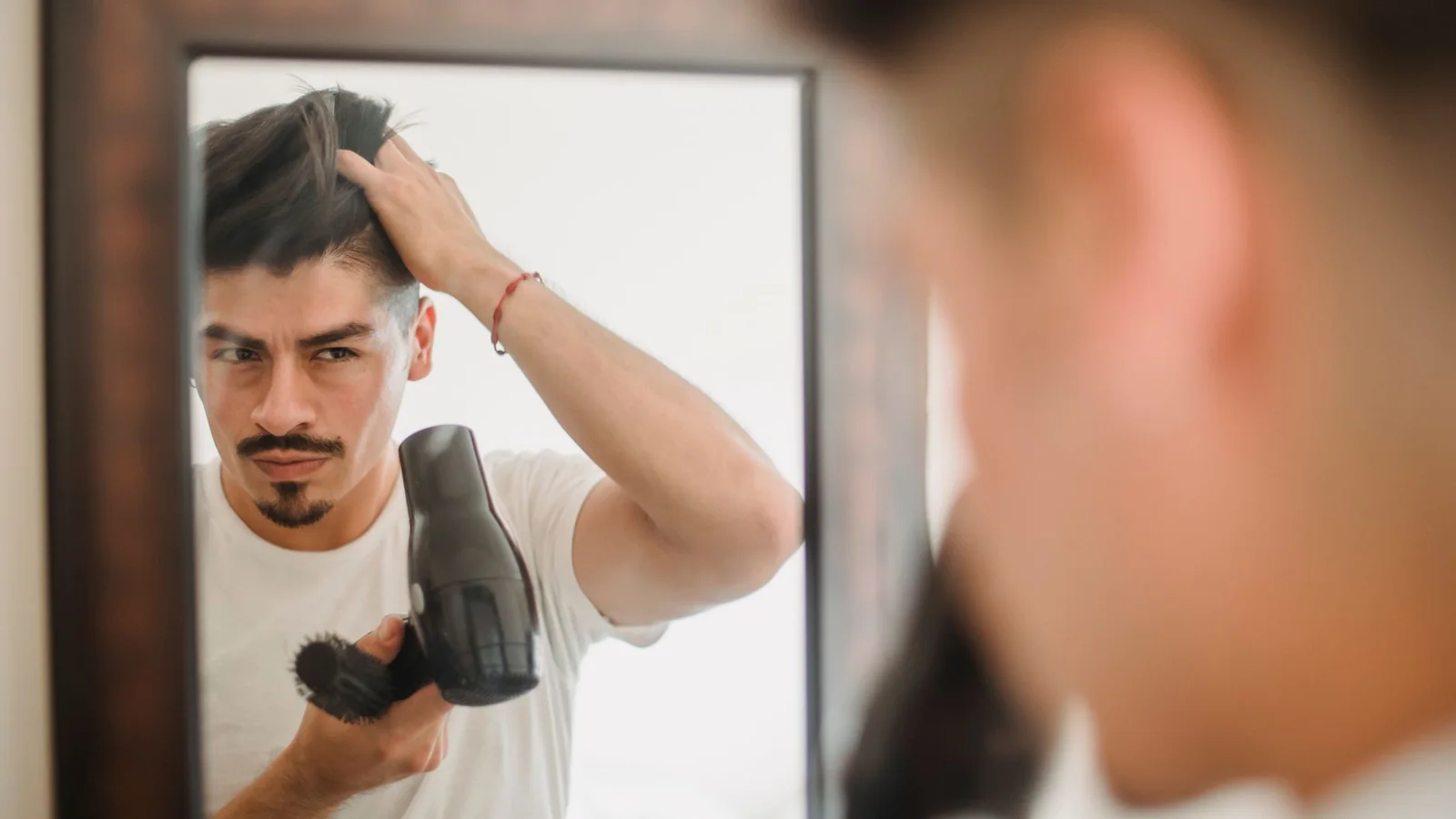 Un secador de pelo y accesorios sobre un mueble de baño ordenado